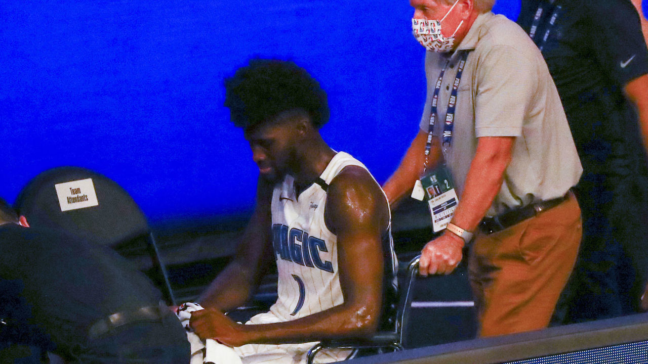 LAKE BUENA VISTA, FLORIDA - AUGUST 02: Jonathan Isaac #1 of the Orlando Magic is helped off the court in a wheelchair after an injury against the Sacramento Kings in the second half of a NBA basketball game at HP Field House at ESPN Wide World Of Sports Complex on August 2, 2020 in Lake Buena Vista, Florida.