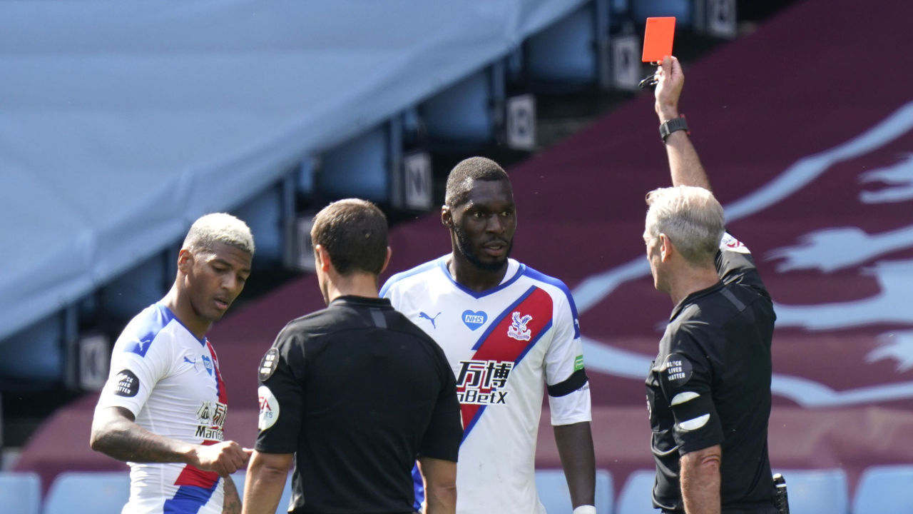 BIRMINGHAM, ENGLAND - JULY 12: Christian Benteke of Crystal Palace is shown the red card by the match referee during the Premier League match between Aston Villa and Crystal Palace at Villa Park on July 12, 2020 in Birmingham, England. Football Stadiums around Europe remain empty due to the Coronavirus Pandemic as Government social distancing laws prohibit fans inside venues resulting in all fixtures being played behind closed doors.