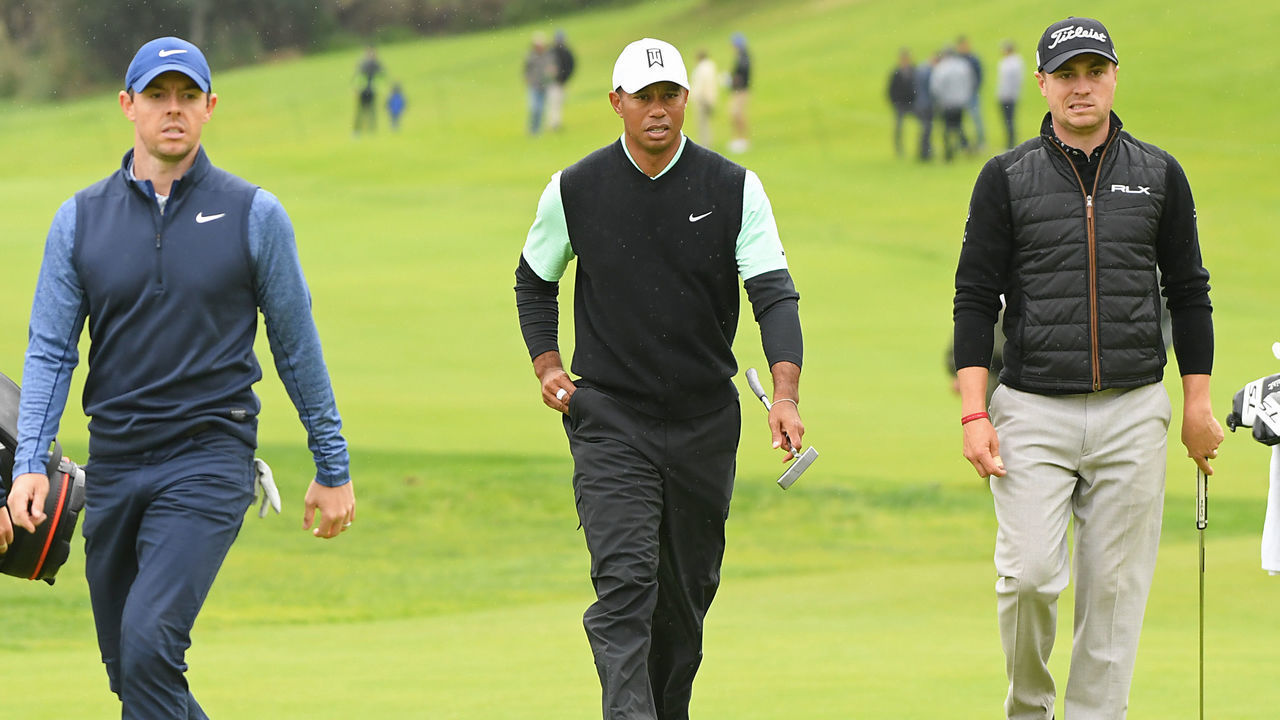 PACIFIC PALISADES, CALIFORNIA - FEBRUARY 15: Rory McIlroy of Northern Ireland, Tiger Woods and Justin Thomas walk up the 18th hole green during the continuation of the first round of the Genesis Open at Riviera Country Club on February 15, 2019 in Pacific Palisades, California