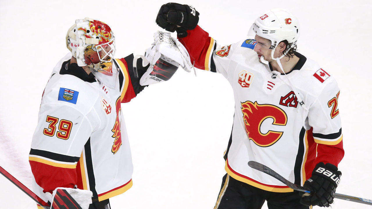 EDMONTON, ALBERTA - AUGUST 04: Cam Talbot #39 of the Calgary Flames celebrates the 6-2 win over the Winnipeg Jets with teammate Sean Monahan #23 after Game Three of the Western Conference Qualification Round prior to the 2020 NHL Stanley Cup Playoffs at Rogers Place on August 04, 2020 in Edmonton, Alberta.