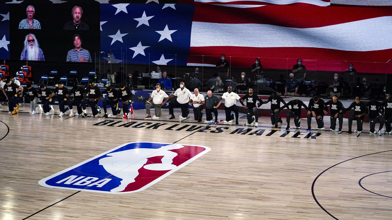 LAKE BUENA VISTA, FLORIDA - AUGUST 4: Members of the Orlando Magic and Indiana Pacers kneel for the National Anthem before an NBA basketball game on August 4, 2020 in Lake Buena Vista, Florida.