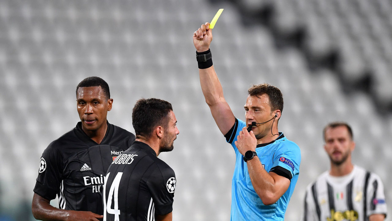 TURIN, ITALY - AUGUST 07: Referee Felix Zwayer awards Leo Dubois of Olympique Lyon a yellow card during the UEFA Champions League round of 16 second leg match between Juventus and Olympique Lyon at Allianz Stadium on August 07, 2020 in Turin, Italy.