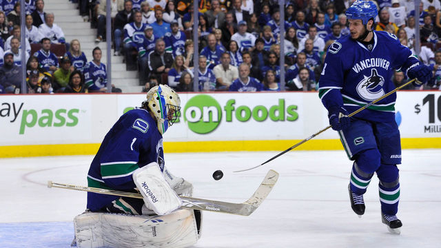 VANCOUVER, CANADA - MAY 24: Goaltender Roberto Luongo #1 of the Vancouver Canucks makes a save as teammate Kevin Bieksa #3 looks on in Game Five of the Western Conference Finals against the San Jose Sharks during the 2011 Stanley Cup Playoffs at Rogers Arena on May 24, 2011 in Vancouver, British Columbia, Canada. The Canucks defeated the Sharks 3-2 in the second overtime to win the Western Conference Finals series 4-1.