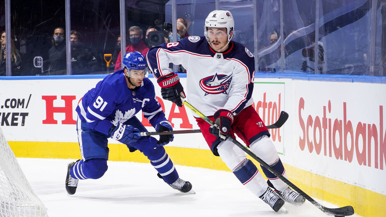 TORONTO, ONTARIO - AUGUST 04: Zach Werenski #8 of the Columbus Blue Jackets plays the puck against John Tavares #91 of the Toronto Maple Leafs during the first period in Game Two of the Eastern Conference Qualification Round at Scotiabank Arena on August 04, 2020 in Toronto, Ontario.