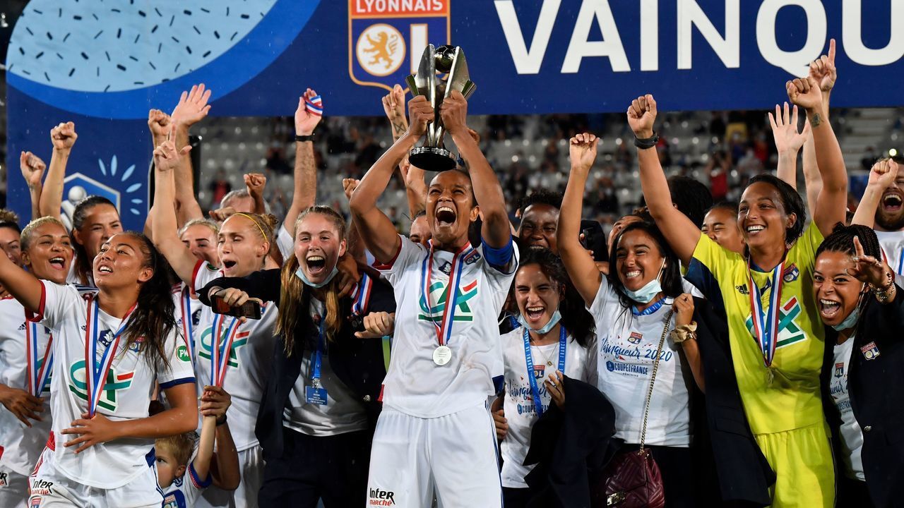 Olympique Lyonnais's French defender Wendie Renard (C) lifts the trophy as Lyon's players celebrate their victory at the end of the French Cup final football match between Olympique Lyonnais (OL) and Paris Saint-Germain (PSG) at the Abbe-Deschamps stadium in Auxerre, on August 9, 2020.