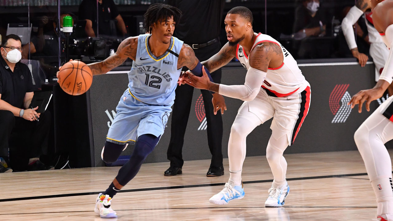 Orlando, FL - JULY 31: Ja Morant #12 of the Memphis Grizzlies handies the ball against Damian Lillard #0 of the Portland Trail Blazers on July 31, 2020 at The Arena at ESPN Wide World Of Sports Complex in Orlando, Florida. NOTE TO USER: User expressly acknowledges and agrees that, by downloading and/or using this Photograph, user is consenting to the terms and conditions of the Getty Images License Agreement. Mandatory Copyright Notice: Copyright 2020 NBAE