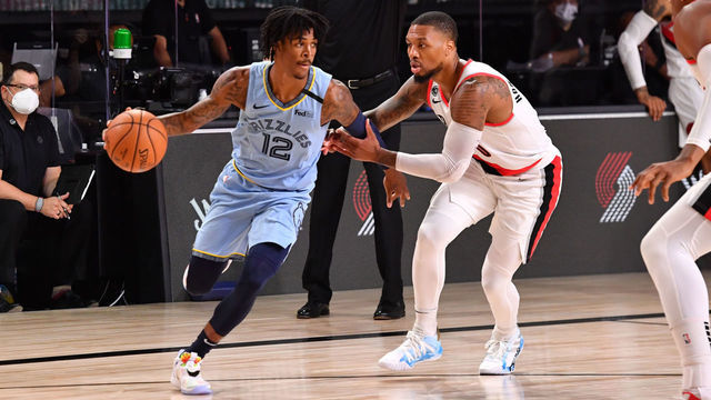Orlando, FL - JULY 31: Ja Morant #12 of the Memphis Grizzlies handies the ball against Damian Lillard #0 of the Portland Trail Blazers on July 31, 2020 at The Arena at ESPN Wide World Of Sports Complex in Orlando, Florida. NOTE TO USER: User expressly acknowledges and agrees that, by downloading and/or using this Photograph, user is consenting to the terms and conditions of the Getty Images License Agreement. Mandatory Copyright Notice: Copyright 2020 NBAE