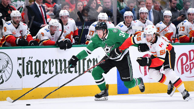 DALLAS, TX - DECEMBER 22: Denis Gurianov #34 of the Dallas Stars tries to keep the puck away against Noah Hanifin #55 of the Calgary Flames at the American Airlines Center on December 22, 2019 in Dallas, Texas.