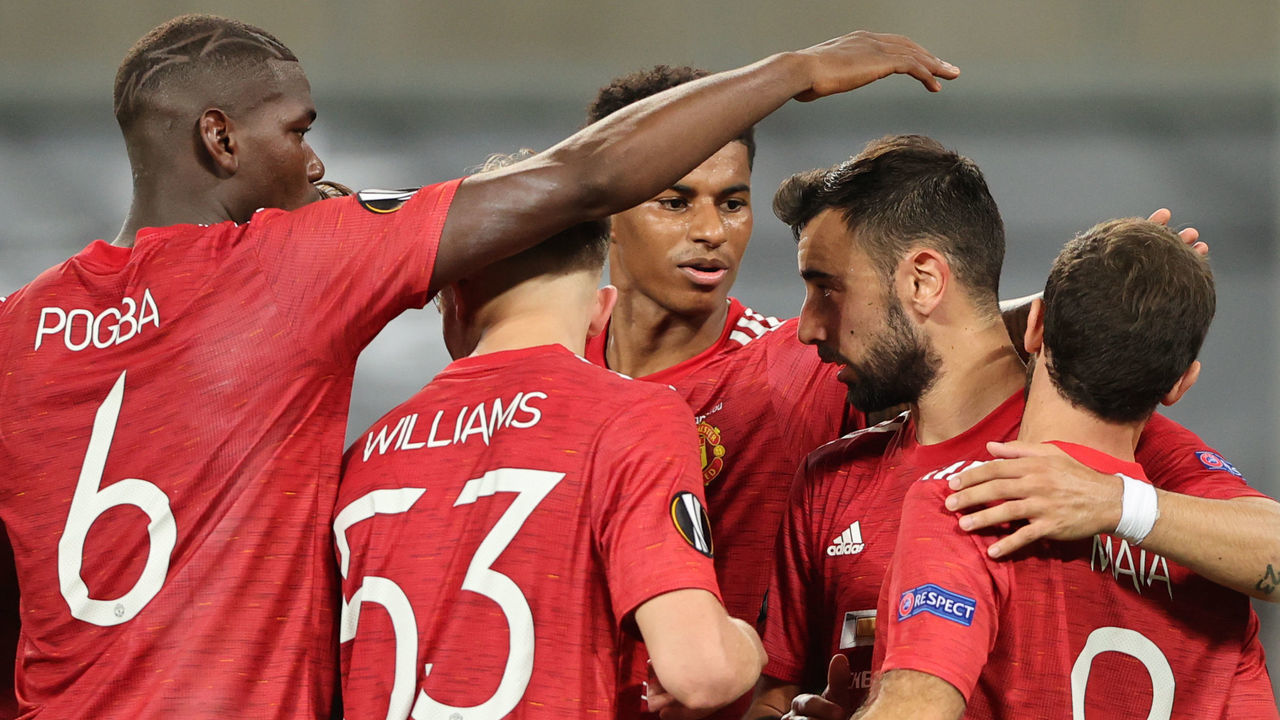 Manchester United's Portuguese midfielder Bruno Fernandes (R) is congratulated by teammates after scoring a penalty during the UEFA Europa League quarter-final football match between Manchester United and FC Copenhagen at the RheinEnergieStadion, in Cologne, western Germany, on August 10, 2020.
