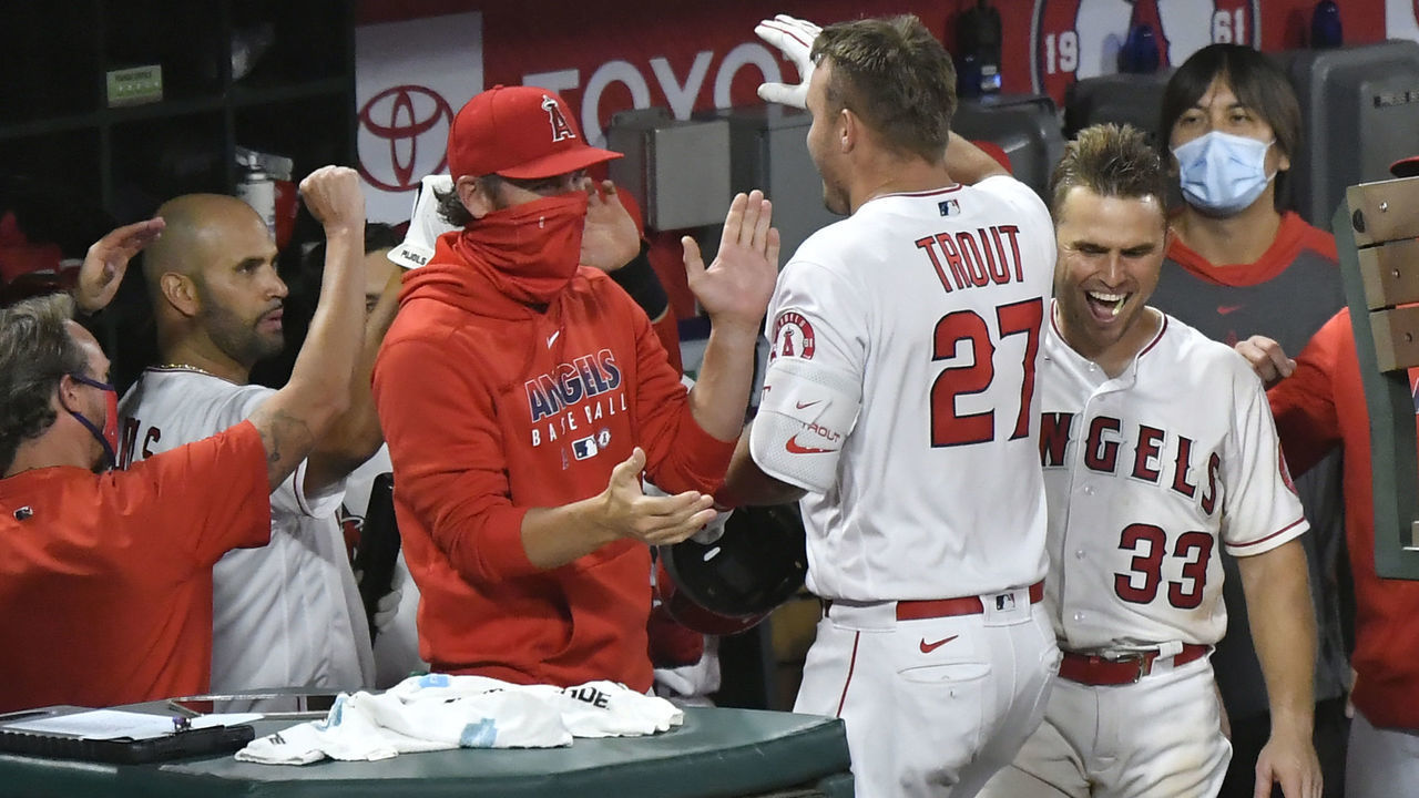 ANAHEIM, CA - AUGUST 10: Mike Trout #27 of the Los Angeles Angels is congratulated in the dugout after he hit a home run against the Oakland Athletics in the eighth inning at Angel Stadium of Anaheim on August 10, 2020 in Anaheim, California.