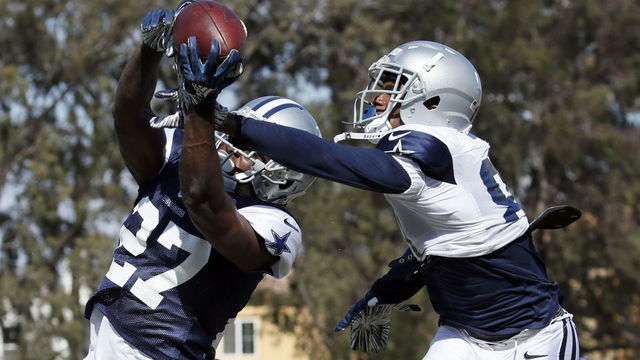 OXNARD, CALIFORNIA - AUGUST 7: Jourdan Lewis #27 of the Dallas Cowboys makes an interception on teammate Jon'Vea Johnson #81 of the Dallas Cowboys on August 7, 2019 in Oxnard, California.