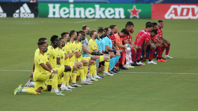 FRISCO, TX - AUGUST 12: FC Dallas Team (R) and Nashville SC Team get to their knees during the national anthem prior the game game between FC Dallas and Nashville SC as part of the Major League Soccer 2020 at Toyota Stadium on August 12, 2020 in Frisco, Texas.