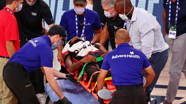 LAKE BUENA VISTA, FLORIDA - AUGUST 14: Derrick Jones Jr. #5 of the Miami Heat is tended to by medical personnel after colliding with Goga Bitadze #88 of the Indiana Pacers (not pictured) during the second half of a NBA basketball game at AdventHealth Arena at ESPN Wide World Of Sports Complex on August 14, 2020 in Lake Buena Vista, Florida.