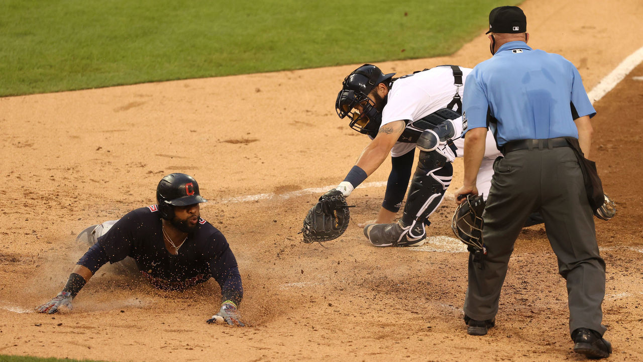 DETROIT, MICHIGAN - AUGUST 14: Delino DeShields #0 of the Cleveland Indians slides past the tag of Austin Romine #7 of the Detroit Tigers to score a run in the forth inning at Comerica Park on August 14, 2020 in Detroit, Michigan.