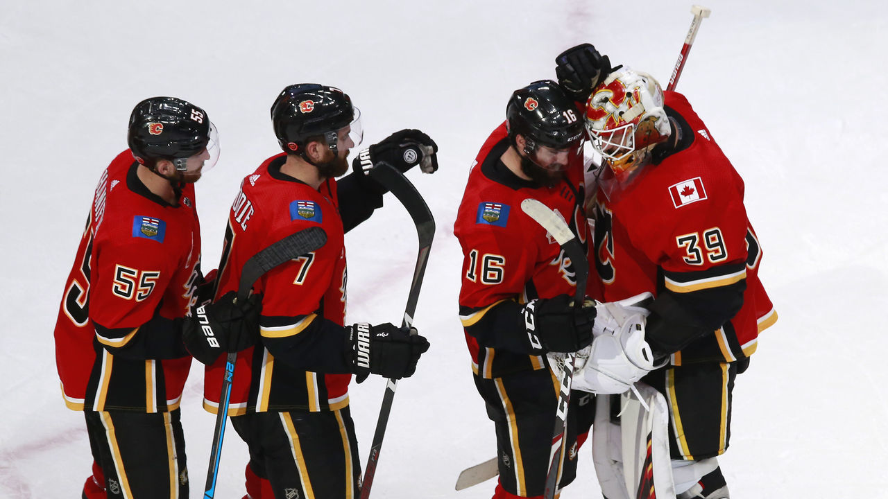 EDMONTON, ALBERTA - AUGUST 14: Cam Talbot #39 of the Calgary Flames is congratulated by his teammates Tobias Rieder #16, TJ Brodie #7 and Noah Hanifin #55 after recording a shutout in the teams 2-0 win against the Dallas Stars in Game Three of the Western Conference First Round during the 2020 NHL Stanley Cup Playoffs at Rogers Place on August 14, 2020 in Edmonton, Alberta, Canada.