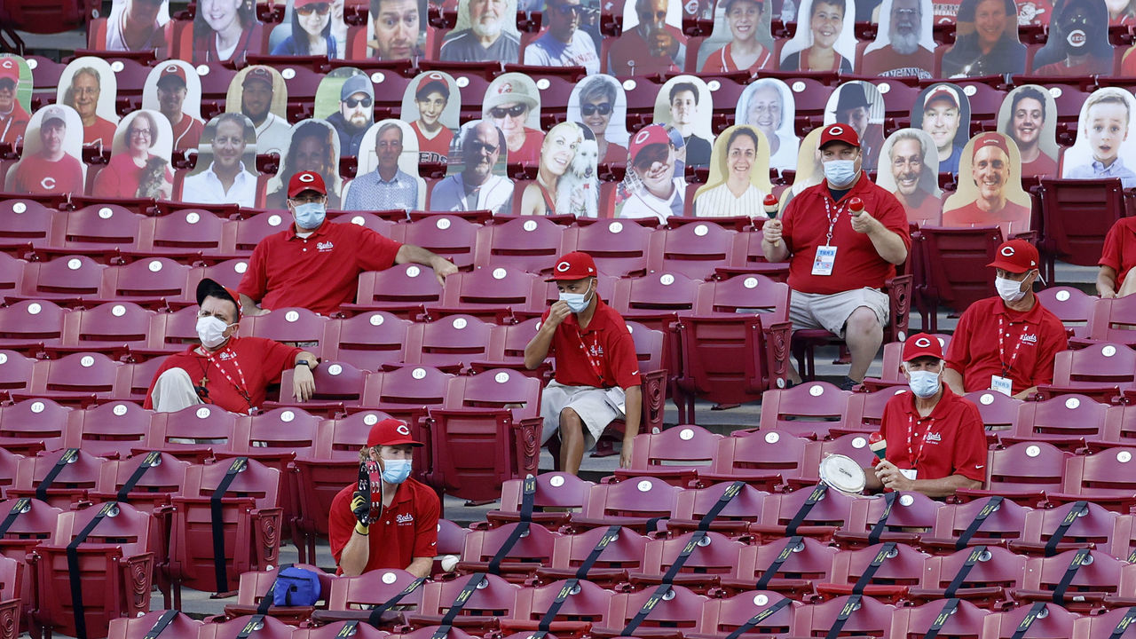 CINCINNATI, OH - AUGUST 11: Members of the Cincinnati Reds field crew cheer on the team while sitting among a section of cardboard fan cutouts in the third inning against the Kansas City Royals at Great American Ball Park on August 11, 2020 in Cincinnati, Ohio.