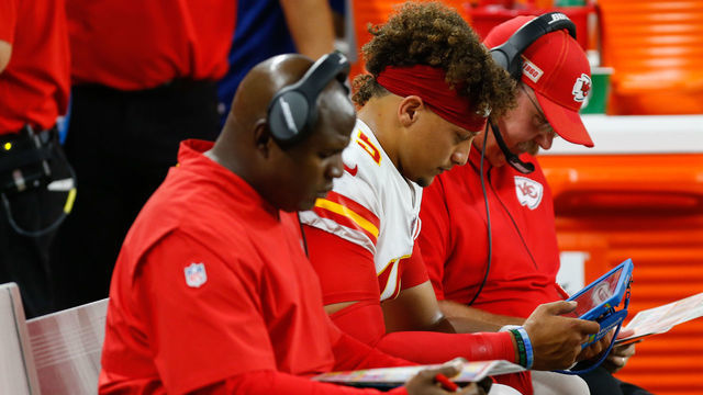 DETROIT, MI - SEPTEMBER 29: Kansas City Chiefs quarterback Patrick Mahomes (15), center, reviews game video on the bench accompanied by Kansas City Chiefs offensive coordinator Eric Bieniemy, left, and Kansas City Chiefs head coach Andy Reid, right, during a regular season game between the Kansas City Chiefs and the Detroit Lions on September 29, 2019 at Ford Field in Detroit, Michigan.