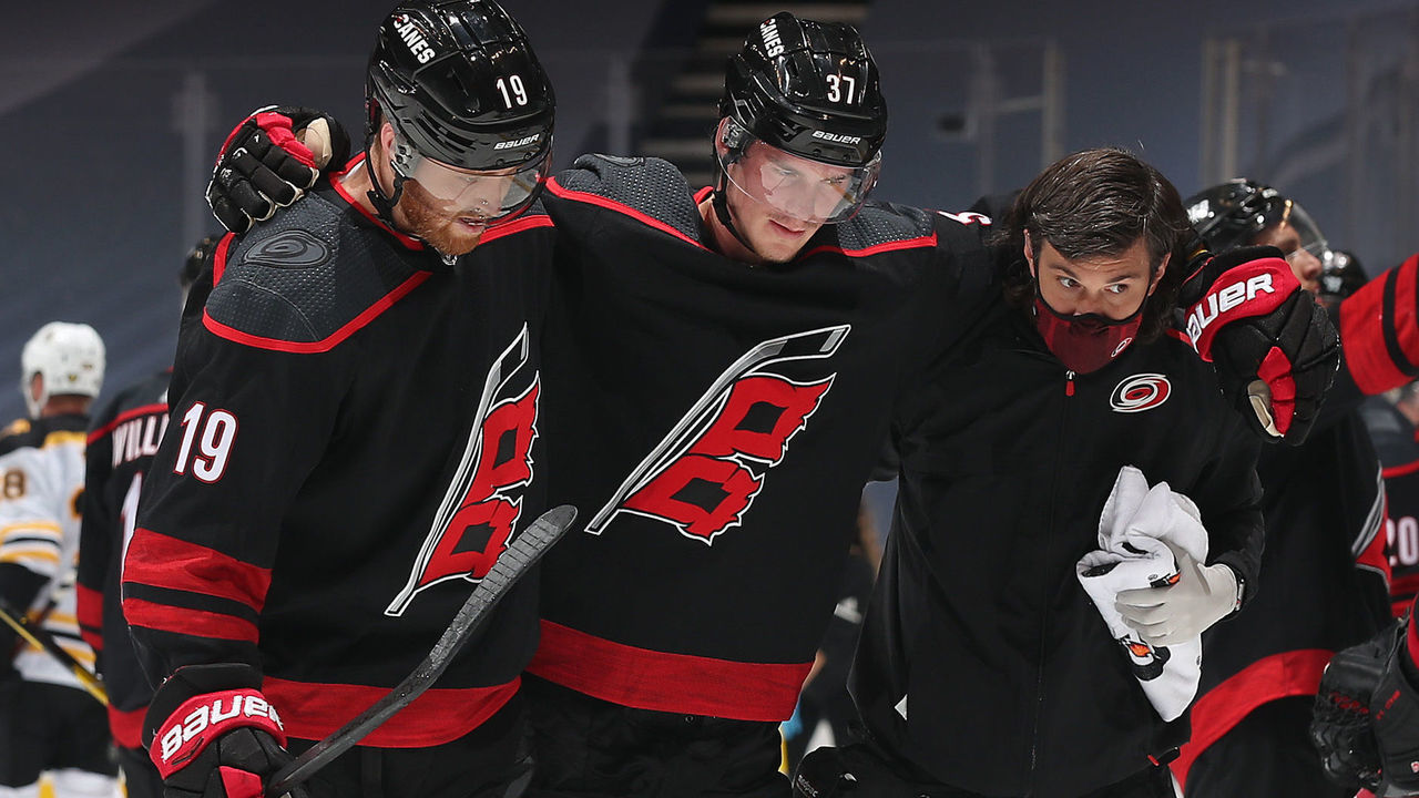 TORONTO, ONTARIO - AUGUST 15: Andrei Svechnikov #37 of the Carolina Hurricanes is helped off the ice by teammate Dougie Hamilton #19 and a team trainer in the third period of Game Three of the Eastern Conference First Round of the 2020 NHL Stanley Cup Playoff between the Boston Bruins and the Carolina Hurricanes at Scotiabank Arena on August 15, 2020 in Toronto, Ontario.