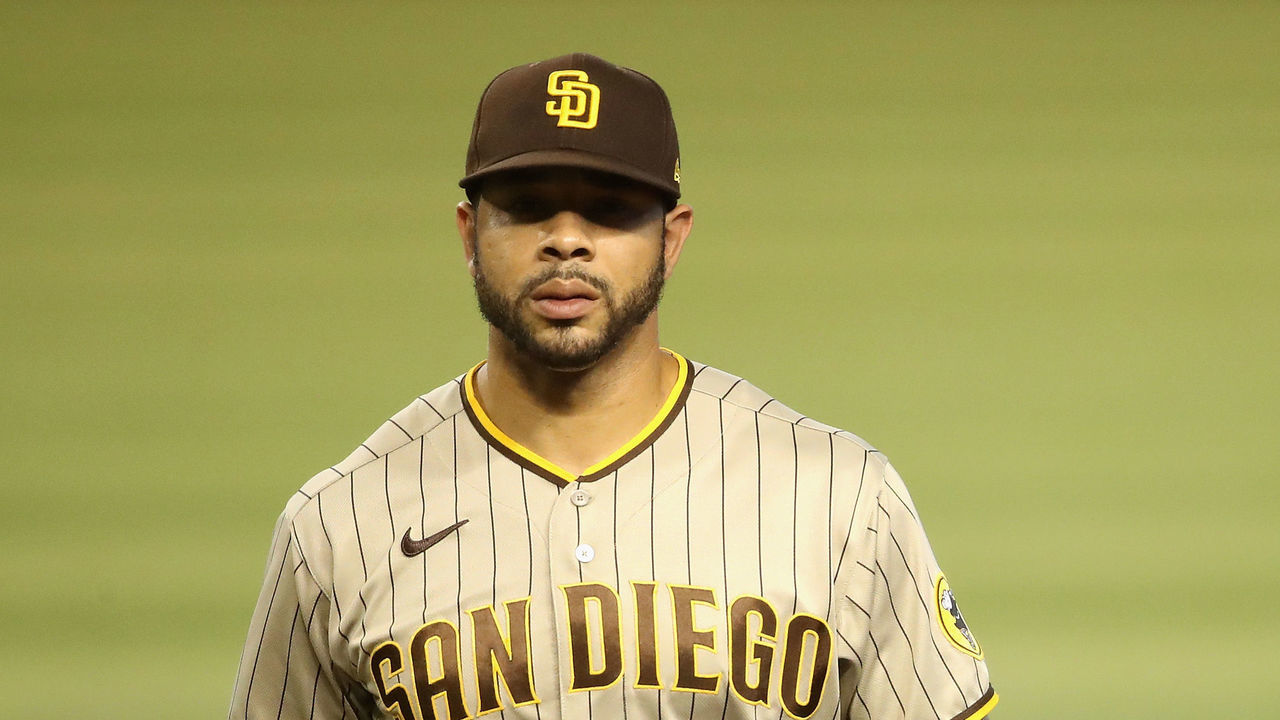 PHOENIX, ARIZONA - AUGUST 15: Outfielder Tommy Pham #28 of the San Diego Padres walks off the field with a team trainer during the second inning of the MLB game against the Arizona Diamondbacks at Chase Field on August 15, 2020 in Phoenix, Arizona.
