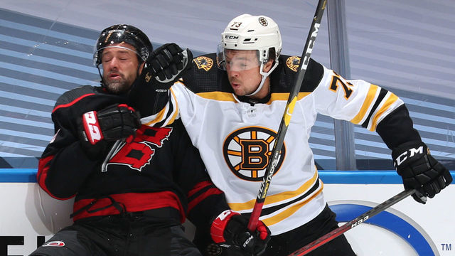 TORONTO, ONTARIO - AUGUST 17: Charlie McAvoy #73 of the Boston Bruins pushes Justin Williams #14 of the Carolina Hurricanes into the boards during the second period of Game Four of the Eastern Conference First Round during the 2020 NHL Stanley Cup Playoffs at Scotiabank Arena on August 17, 2020 in Toronto, Ontario.