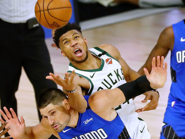 LAKE BUENA VISTA, FLORIDA - AUGUST 18: Giannis Antetokounmpo #34 of the Milwaukee Bucks fouls Nikola Vucevic #9 of the Orlando Magic while reaching for a loose ball in the second half during Game One in the first round of the NBA playoffs at The Field House at ESPN Wide World Of Sports Complex on August 18, 2020 in Lake Buena Vista, Florida. NOTE TO USER: User expressly acknowledges and agrees that, by downloading and/or using this Photograph, user is consenting to the terms and conditions of the Getty Images License Agreement.