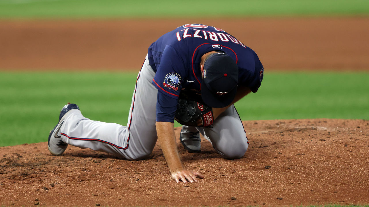 KANSAS CITY, MISSOURI - AUGUST 21: Starting pitcher Jake Odorizzi #12 of the Minnesota Twins falls to the ground after being hit by the ball during the 4th inning of the game against the Kansas City Royals at Kauffman Stadium on August 21, 2020 in Kansas City, Missouri.