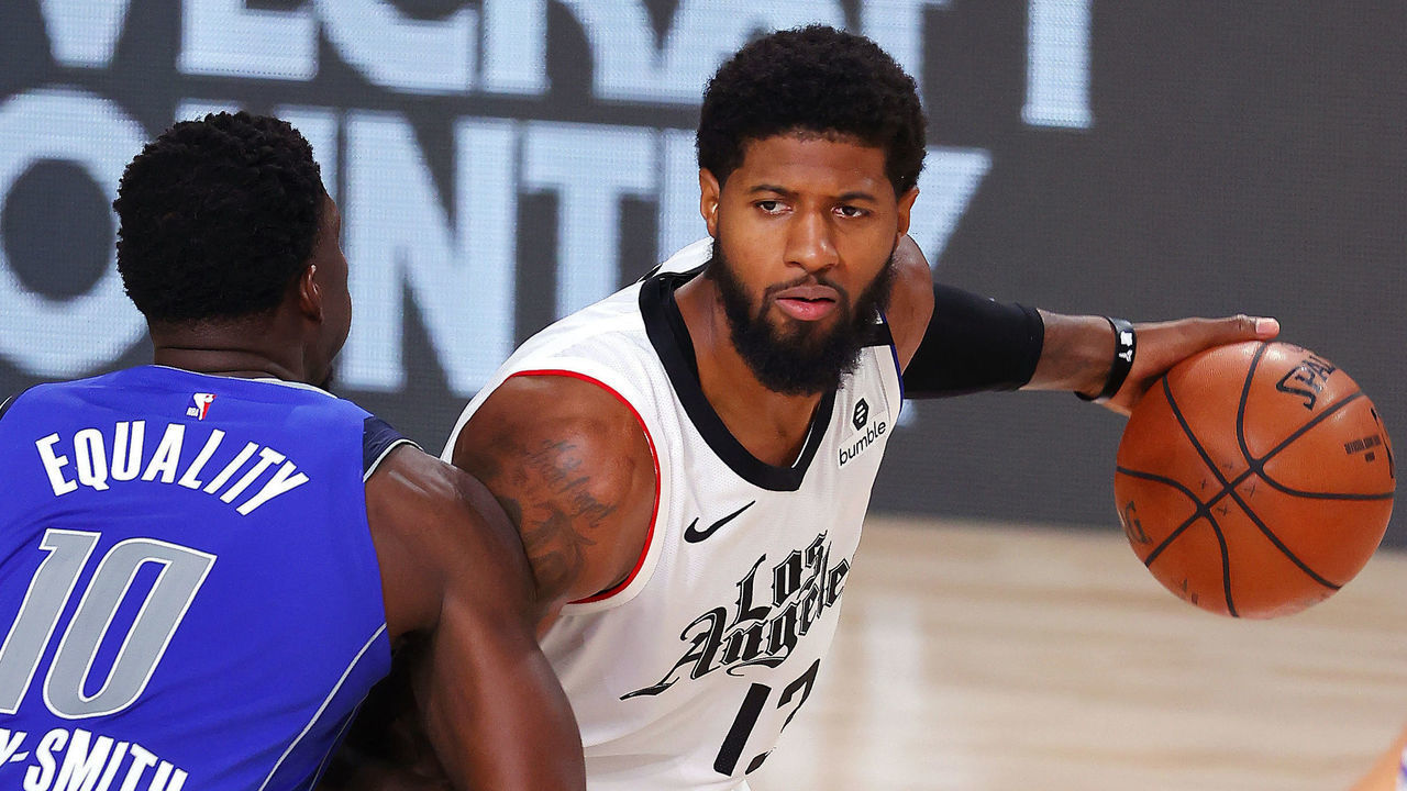 LAKE BUENA VISTA, FLORIDA - AUGUST 21: Paul George #13 of the LA Clippers looks to pass against Dorian Finney-Smith #10 of the Dallas Mavericks during the fourth quarter in Game Three of the Western Conference First Round during the 2020 NBA Playoffs at AdventHealth Arena at ESPN Wide World Of Sports Complex on August 21, 2020 in Lake Buena Vista, Florida.