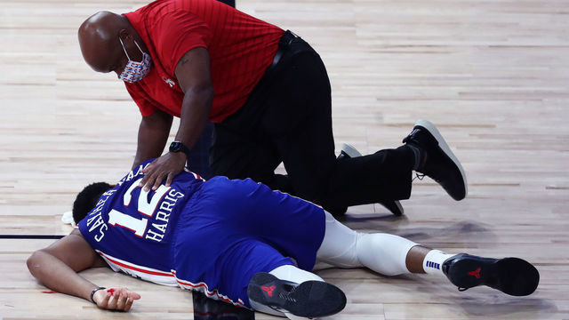 LAKE BUENA VISTA, FLORIDA - AUGUST 23: Tobias Harris #12 of the Philadelphia 76ers is attended to after hitting his head during the third quarter against the Boston Celtics in Game Four of the first round of the playoffs at The Field House at ESPN Wide World Of Sports Complex on August 23, 2020 in Lake Buena Vista, Florida.