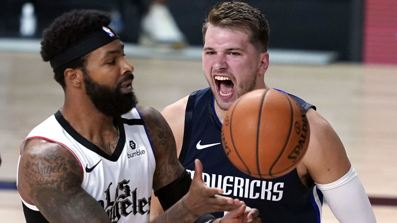 LAKE BUENA VISTA, FLORIDA - AUGUST 23: Luka Doncic #77 of the Dallas Mavericks reacts after making a basket as Marcus Morris Sr. #31 of the LA Clippers reaches for the ball during the second half of Game Four of the first round of the playoffs between the Los Angeles Clippers and the Dallas Mavericks at the AdventHealth Arena at the ESPN Wide World Of Sports Complex on August 22, 2020 in Lake Buena Vista, Florida.
