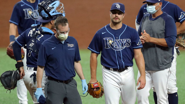 ST. PETERSBURG, FL - AUGUST 25: Jalen Beeks #68 of the Tampa Bay Rays walks off with a member of the medical staff as manager Kevin Cash (R) looks on against the Baltimore Orioles in the ninth inning of a baseball game at Tropicana Field on August 25, 2020 in St. Petersburg, Florida.