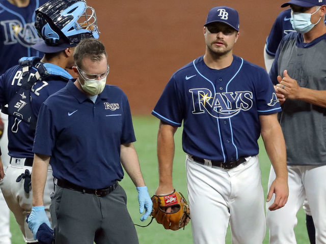 ST. PETERSBURG, FL - AUGUST 25: Jalen Beeks #68 of the Tampa Bay Rays walks off with a member of the medical staff as manager Kevin Cash (R) looks on against the Baltimore Orioles in the ninth inning of a baseball game at Tropicana Field on August 25, 2020 in St. Petersburg, Florida.