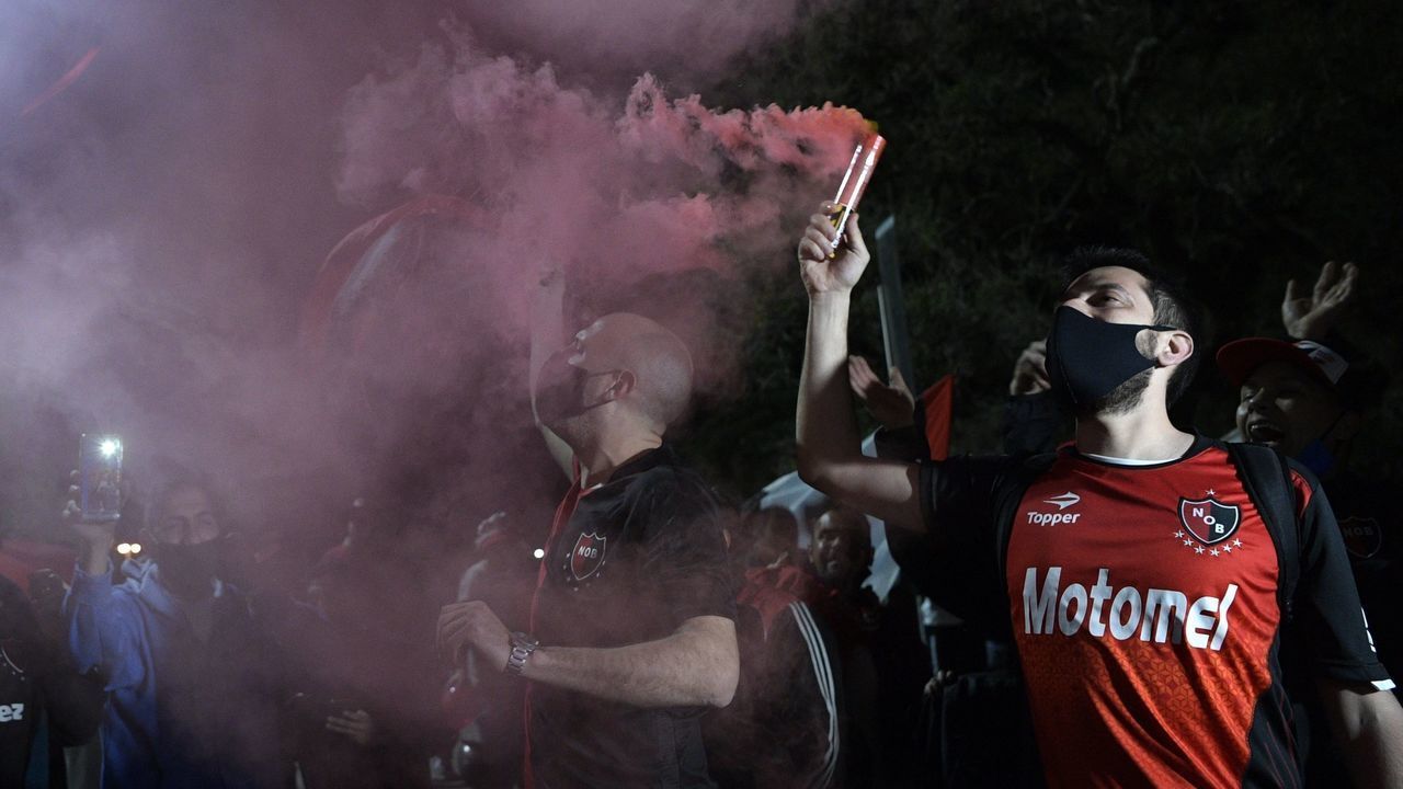 Argentina's Newells Old Boys supporters wave a flares in front of the Monumento de la Bandera during a convoy requesting Argentine footballer Lionel Messi to come play in the team where he started, in Rosario, Santa Fe Province, some 350 km north of Buenos Aires, on August 27, 2020. - Six-time Ballon d'Or winner Lionel Messi told Barcelona he wants to leave -- on a free transfer -- in a "bombshell" fax on Tuesday that is expected to spark a legal battle over a buy-out clause worth hundreds of millions of dollars.
