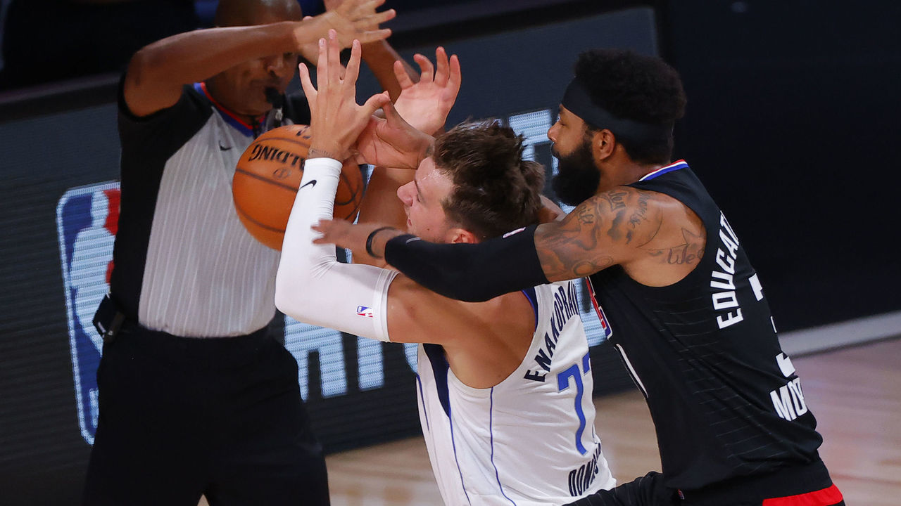 LAKE BUENA VISTA, FLORIDA - AUGUST 30: Marcus Morris Sr. #31 of the LA Clippers fouls Luka Doncic #77 of the Dallas Mavericks during the first quarter in Game Six of the Western Conference First Round during the 2020 NBA Playoffs at AdventHealth Arena at ESPN Wide World Of Sports Complex on August 30, 2020 in Lake Buena Vista, Florida. Morris was ejected from the game after the play.