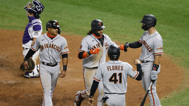DENVER, CO - SEPTEMBER 01: Brandon Crawford #35 of the San Francisco Giants (C) is congratulated by Donovan Solano #7 (2L), Wilmer Flores #41 and Joey Bart #21 as catcher Tony Wolters #14 of the Colorado Rockies kneels behind the plate during the sixth inning at Coors Field on September 1, 2020 in Denver, Colorado.