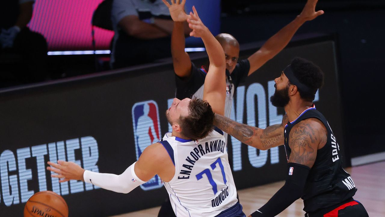 LAKE BUENA VISTA, FLORIDA - AUGUST 30: Marcus Morris Sr. #31 of the LA Clippers fouls Luka Doncic #77 of the Dallas Mavericks during the first quarter in Game Six of the Western Conference First Round during the 2020 NBA Playoffs at AdventHealth Arena at ESPN Wide World Of Sports Complex on August 30, 2020 in Lake Buena Vista, Florida. Morris was ejected from the game after the play.