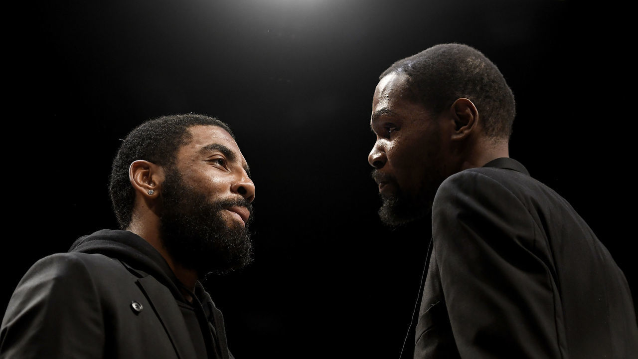 NEW YORK, NEW YORK - JANUARY 10: Kyrie Irving #11 (left) talks with Kevin Durant #7 of the Brooklyn Nets during a timeout during the first half of the game against the Miami Heat at Barclays Center on January 10, 2020 in the Brooklyn borough of New York City. Both players were on the bench due to injury.