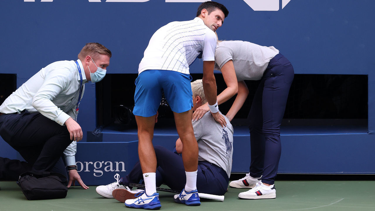 NEW YORK, NEW YORK - SEPTEMBER 06: Novak Djokovic of Serbia tends to a lineswoman after inadvertently striking her with a ball hit in frustration during his Men's Singles fourth round match against Pablo Carreno Busta of Spain on Day Seven of the 2020 US Open at the USTA Billie Jean King National Tennis Center on September 6, 2020 in the Queens borough of New York City.