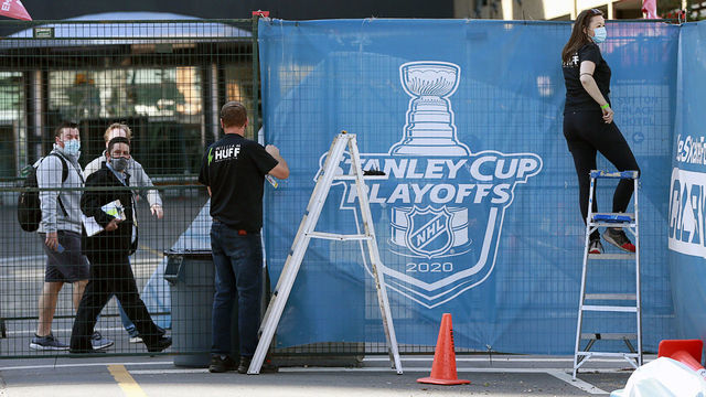 EDMONTON, ALBERTA - AUGUST 10: Workers hang banners along a protective walkway for people inside the NHL bubble on August 10, 2020 during the 2020 NHL Stanley Cup Playoffs in Edmonton, Alberta, Canada.