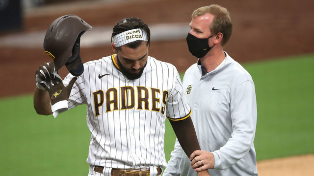 SAN DIEGO, CALIFORNIA - SEPTEMBER 07: Eric Hosmer #30 of the San Diego Padres has his hand looked at by a team trainer after being hit by a pitch during the first inning of a game against the Colorado Rockies at PETCO Park on September 07, 2020 in San Diego, California. Hosmer would leave the game after being hit in the hand.