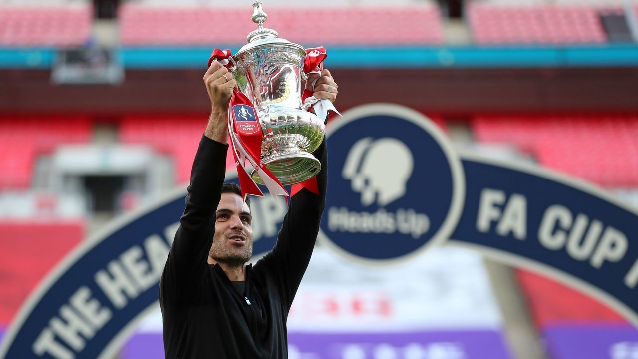 Arsenal's Spanish head coach Mikel Arteta holds the winner's trophy as the team celebrates victory after the English FA Cup final football match between Arsenal and Chelsea at Wembley Stadium in London, on August 1, 2020. - Arsenal won the match 2-1.