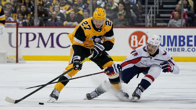 PITTSBURGH, PA - MARCH 07: Pittsburgh Penguins Center Nick Bjugstad (27) and Washington Capitals Left Wing Richard Panik (14) battle for the puck during the third period in the NHL game between the Pittsburgh Penguins and the Washington Capitals on March 7, 2020, at PPG Paints Arena in Pittsburgh, PA.
