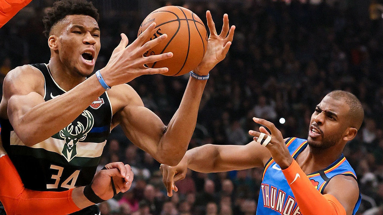 MILWAUKEE, WISCONSIN - FEBRUARY 28: Giannis Antetokounmpo #34 of the Milwaukee Bucks dribbles the ball while being guarded by Steven Adams #12 and Chris Paul #3 of the Oklahoma City Thunder in the second quarter at the Fiserv Forum on February 28, 2020 in Milwaukee, Wisconsin.
