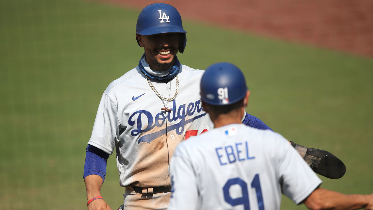 SAN DIEGO, CALIFORNIA - SEPTEMBER 16: Mookie Betts #50 reacts with third base coach Dino Ebel after scoring on an RBI double by Will Smith #16 of the Los Angeles Dodgers during the fifth inning of a game against the San Diego Padres at PETCO Park on September 16, 2020 in San Diego, California.
