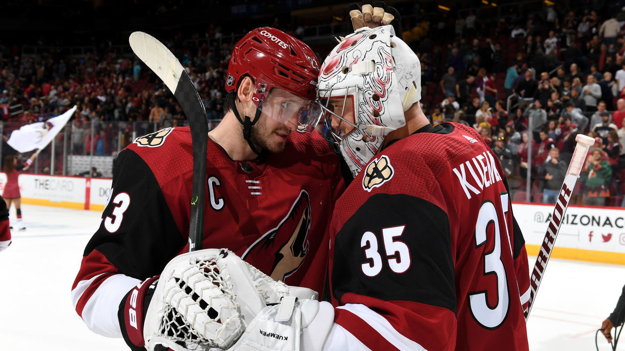GLENDALE, ARIZONA - OCTOBER 17: Goalie Darcy Kuemper #35 of the Arizona Coyotes is congratulated by teammate Oliver Ekman-Larsson #23 following a 5-2 victory against the Nashville Predators at Gila River Arena on October 17, 2019 in Glendale, Arizona.