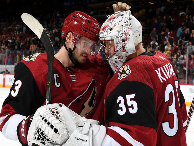 GLENDALE, ARIZONA - OCTOBER 17: Goalie Darcy Kuemper #35 of the Arizona Coyotes is congratulated by teammate Oliver Ekman-Larsson #23 following a 5-2 victory against the Nashville Predators at Gila River Arena on October 17, 2019 in Glendale, Arizona.