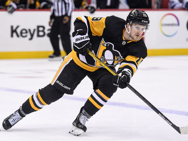 PITTSBURGH, PA - FEBRUARY 11: Pittsburgh Penguins Left Wing Jared McCann (19) passes the puck during the overtime period in the NHL game between the Pittsburgh Penguins and the Tampa Bay Lightning on February 11, 2020, at PPG Paints Arena in Pittsburgh, PA.