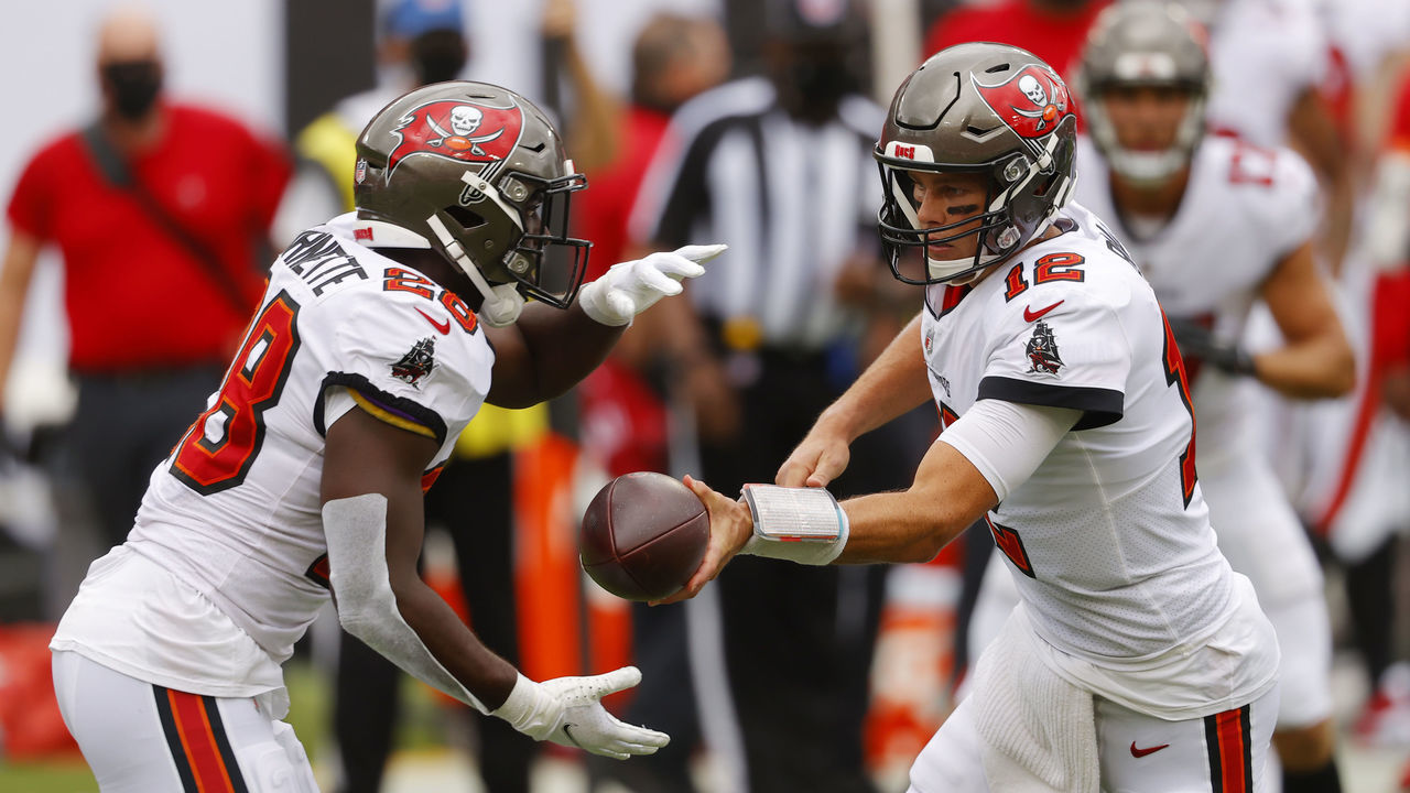 TAMPA, FLORIDA - SEPTEMBER 20: Tom Brady #12 of the Tampa Bay Buccaneers hands the ball off to Leonard Fournette #28 during the first half against the Carolina Panthers at Raymond James Stadium on September 20, 2020 in Tampa, Florida.