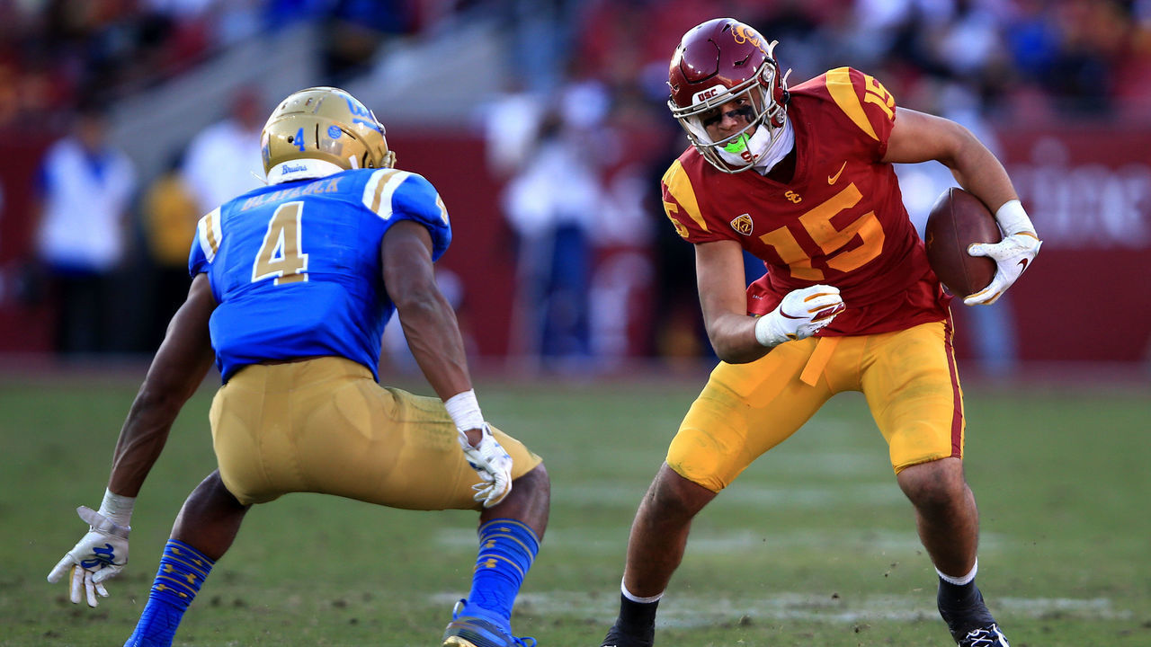 LOS ANGELES, CALIFORNIA - NOVEMBER 23: Drake London #15 of the USC Trojans runs for extra yards as Stephan Blaylock #4 of the UCLA Bruins defends during the second half of a game at Los Angeles Memorial Coliseum on November 23, 2019 in Los Angeles, California.