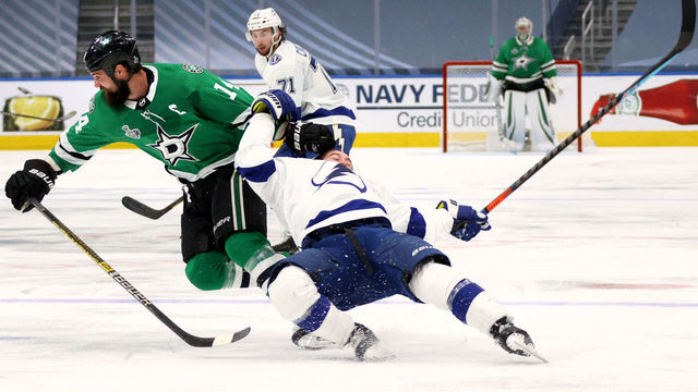 EDMONTON, ALBERTA - SEPTEMBER 25: Jamie Benn #14 of the Dallas Stars takes down Tyler Johnson #9 of the Tampa Bay Lightning in the first overtime period of Game Four of the NHL Stanley Cup Final between the Tampa Bay Lightning and the Dallas Stars at Rogers Place on September 25, 2020 in Edmonton, Alberta, Canada. Benn was given a two-minute minor penalty for tripping for the take down of Johnson.