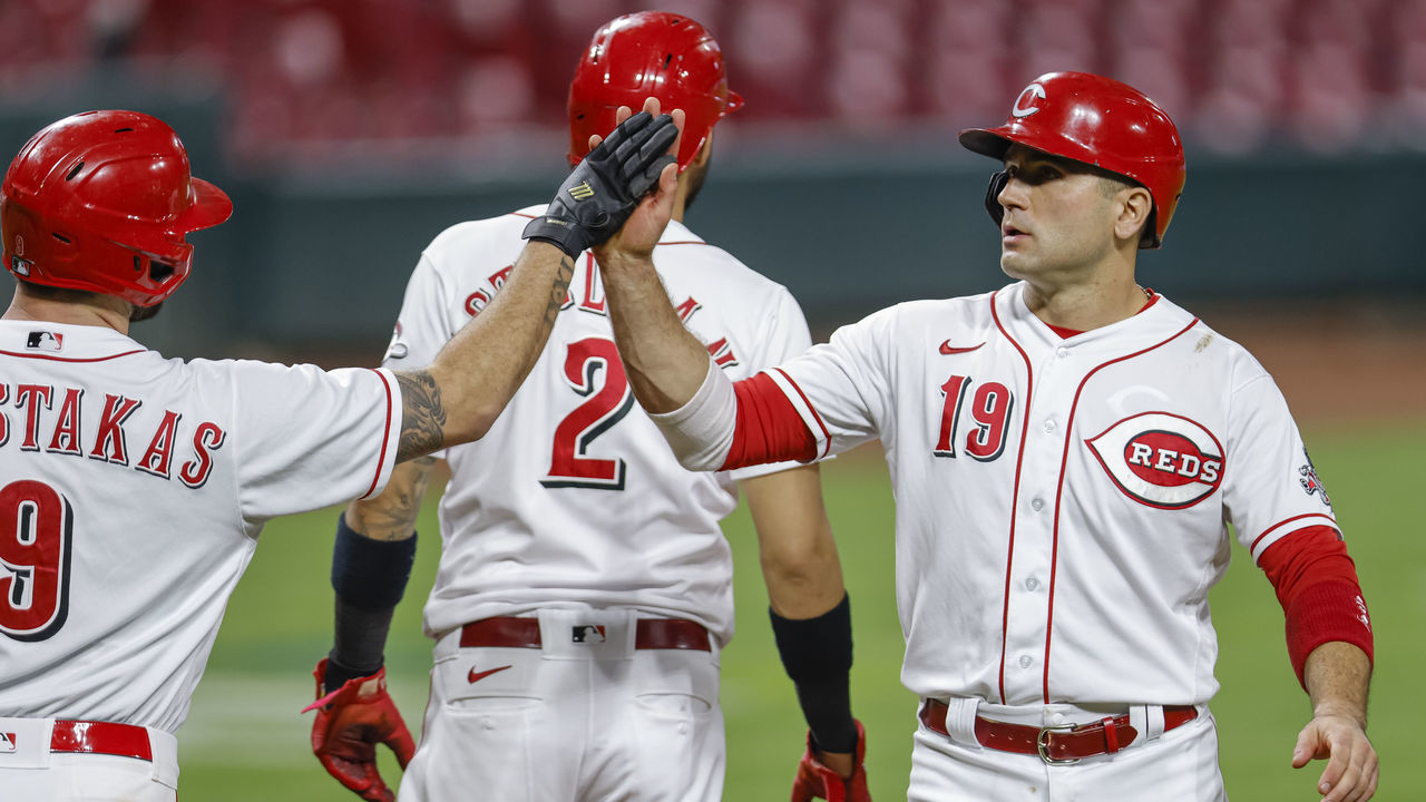 CINCINNATI, OH - SEPTEMBER 23: Mike Moustakas #9 and Joey Votto #19 of the Cincinnati Reds celebrate during the game against the Milwaukee Brewers at Great American Ball Park on September 23, 2020 in Cincinnati, Ohio.